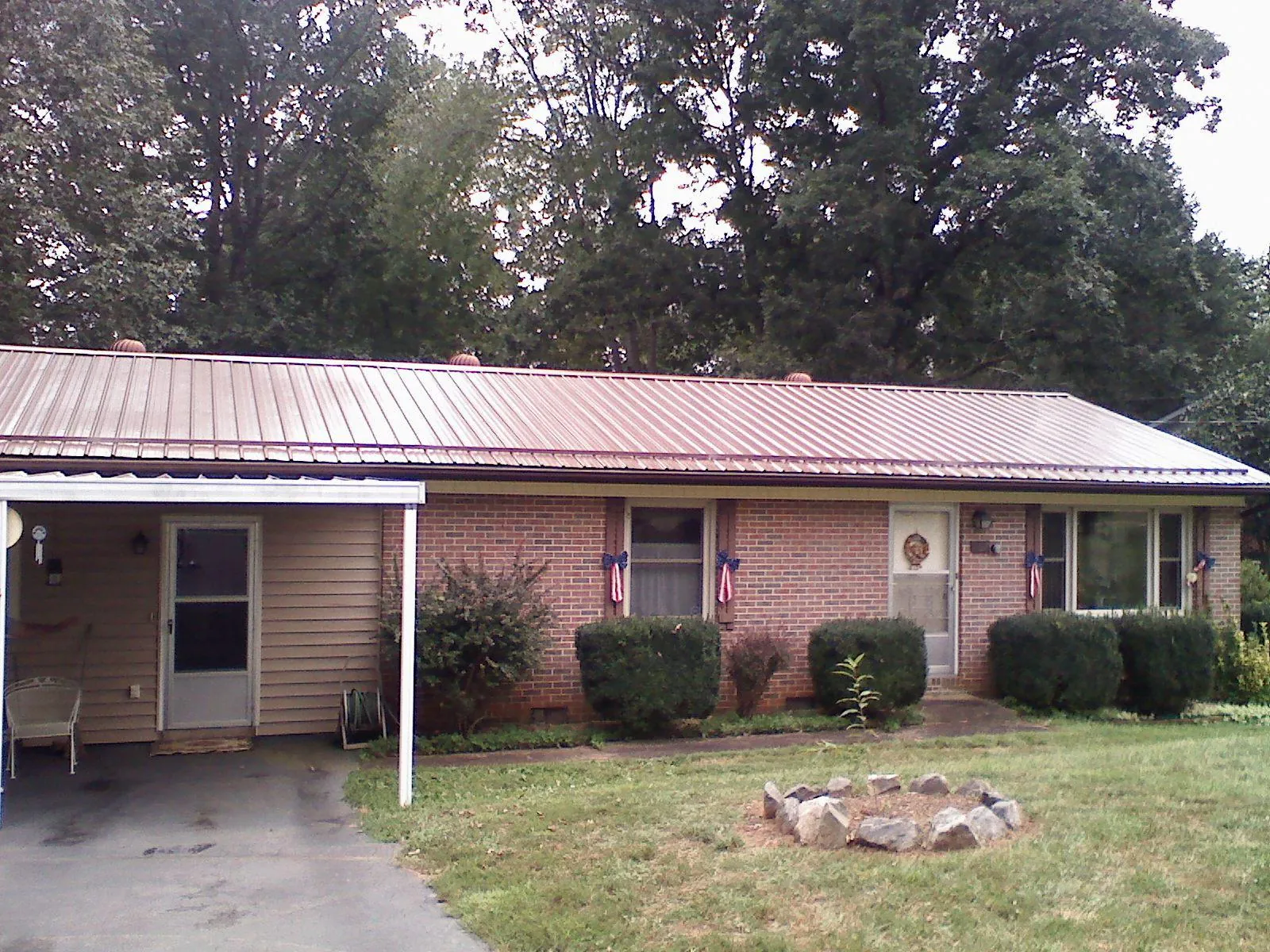 Bronze metal roof and carport on a brick ranch home — Roof Repair work by our crew in Robbins